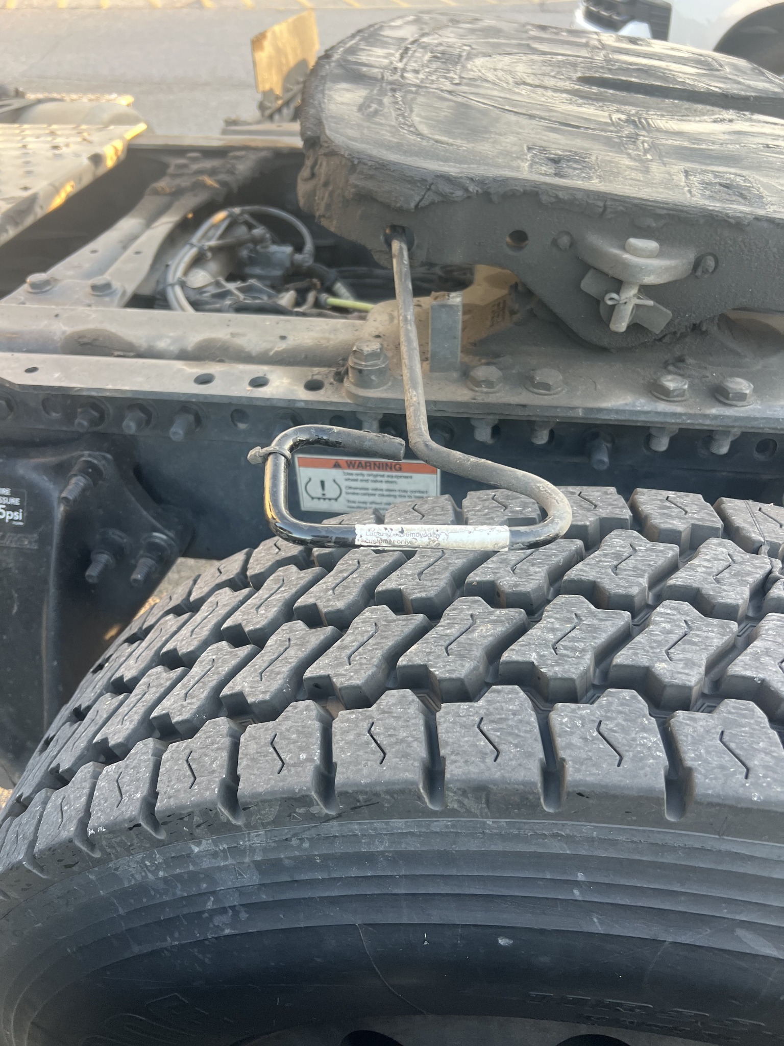 Semi-truck chassis, rear tire, and fifth-wheel coupling at a service job